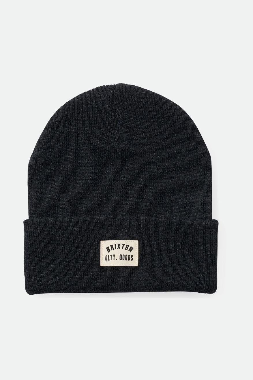 A black fisherman's beanie with a thick cuff and a small white label on the front that reads 'Brixton QLTY GOODS'.